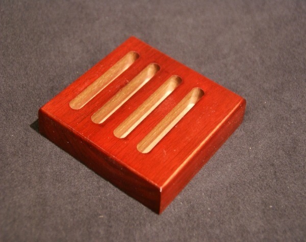 Slotted wooden soap dish stained red, available in bulk for manufacturers and high-volume production.